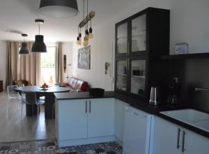 a kitchen with white cabinets and a table in it at Chez Monsieur le directeur de la poste in Piégut-Pluviers