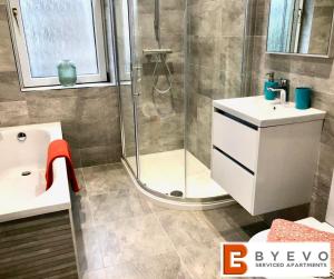 uma casa de banho com um chuveiro e um lavatório. em ByEvo Almar Villa - Comfy Contractor or Large groups property em Glasgow