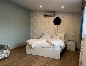 a bedroom with a white bed and a wall at Bright Guesthouse in the center of Yerevan! in Yerevan