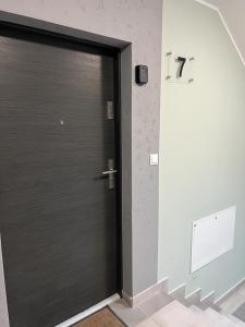 una porta nera in una stanza con un muro di Kawalerka Wałowa 7 a Wejherowo