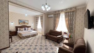 ein Schlafzimmer mit einem Bett, einem Sofa und einem Stuhl in der Unterkunft Hotel Asia Bukhara in Buxoro