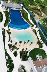 - une vue aérienne sur la piscine du complexe bordée de palmiers dans l'établissement Minimalist Studio Unit at Azure North San Fernando Pampanga, à San Fernando