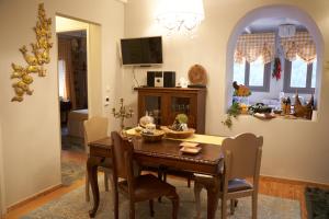 a dining room with a wooden table and chairs at Dandy Villas Dimitsana - a family ideal charming home in a quaint historic neighborhood - 2 fireplaces for romantic nights in Dimitsana