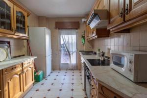 cocina con nevera blanca y microondas en Hermanos Pinzón Apartamento, en Zamora