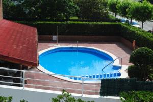 a large swimming pool with a red roof at Apartamentos Regollera Premium con garaje in Noja