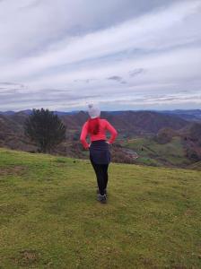 Una mujer corriendo en la cima de una colina en Casa de Ligueria, en Rozapanera