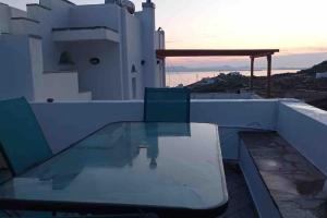 a glass table on the roof of a house at 7Days-Suite & SeaView in Agkidia