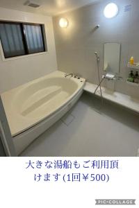 ein Badezimmer mit einer Badewanne, einem Waschbecken und einem Spiegel in der Unterkunft IslandHonu in Ishigaki-jima