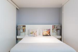 a bedroom with a large white bed with pillows at FLH Baixa-Chiado Library Loft in Lisbon