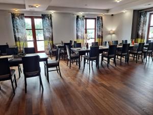 een eetkamer met tafels, stoelen en ramen bij Hotel Barczyzna Medical Spa in Nekla