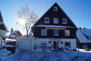 Maison noire et blanche avec garage blanc dans l'établissement Hotel Pension De Gasterei, à Winterberg