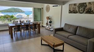 ein Wohnzimmer mit einem Sofa, einem Tisch und Stühlen in der Unterkunft Pinel Superbe appartement en résidence VUE MER in Cul de Sac