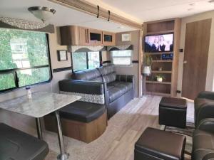 a living room and dining room in a rv at Kokomo Farms in Live Oak