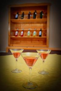 drie martini glazen zittend op een tafel met wijnflessen bij Зелената Къща 