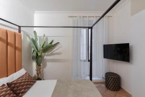 a bedroom with a bed and a tv on a wall at A World Aparts - 21 T. Argentina in Rome +15 photos