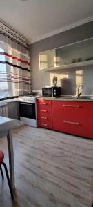 uma cozinha com gavetas vermelhas e um armário vermelho em Apart рядом с MEGA Аlma-Ata em Almaty