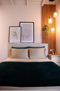 sypialnia z łóżkiem z dwoma obrazami na ścianie w obiekcie maison jamouri w mieście Kríni