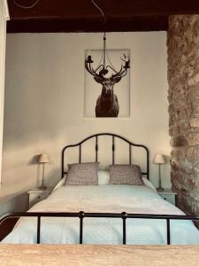 a bedroom with a bed with a deer head on the wall at Maison du petit Poète in Quarré-les-Tombes