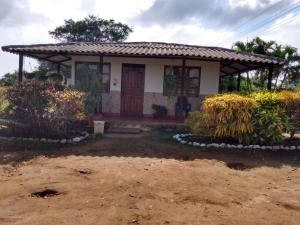 una pequeña casa con una puerta de madera en un patio en Cabana De Descanso, Isla De Baru - Cartagena - Rest Cabin, Baru Island -Bolivar, en Playa Blanca