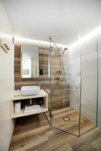 uma casa de banho com uma cabina de duche em vidro e um lavatório. em VILLA NOSAL - Zakopane em Zakopane