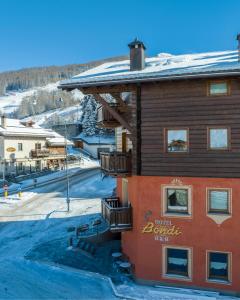 un edificio con balcón en una ladera nevada en Hotel Bondi, en Livigno