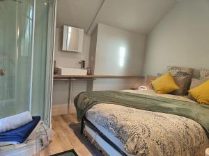 1 dormitorio con 1 cama con almohadas amarillas en La petite maison, en Dinan