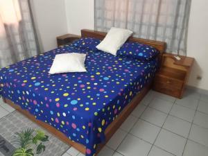 a bedroom with a bed with polka dots on it at Guesthouse Rotimex in Lomé