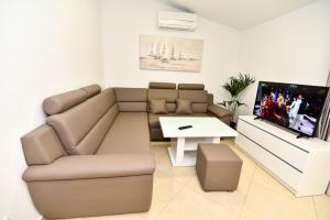 a living room with a couch and a tv at Apartments Sana 2 in Vir
