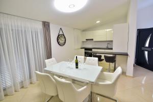 a dining room with a white table and white chairs at Apartments Sana 2 in Vir