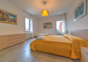 - une chambre avec un grand lit et une couverture jaune dans l'établissement Cà Laguna Lido, sur le Lido de Venise