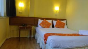 een hotelkamer met 2 bedden met oranje kussens bij Asia Inn Bangkok 2022 in Bangkok