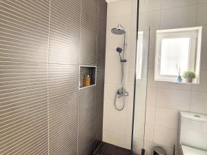 une douche avec une porte vitrée dans une salle de bain dans l'établissement Casa Pico dos Barcelos by LovelyStay, à Funchal