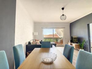 una sala da pranzo con tavolo in legno e sedie blu di Casa Pico dos Barcelos by LovelyStay a Funchal