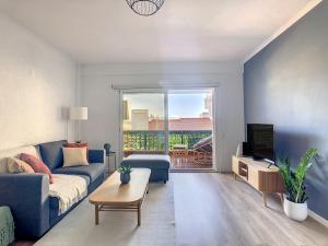 un soggiorno con divano blu e TV di Casa Pico dos Barcelos by LovelyStay a Funchal