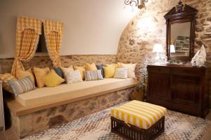 a couch with pillows on it in a room at Dandy Villas Dimitsana - a family ideal charming home in a quaint historic neighborhood - 2 fireplaces for romantic nights in Dimitsana