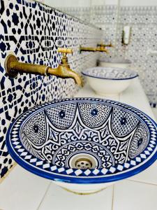 baño con lavabo azul y blanco en una encimera en Darna Hostel en Tetuán