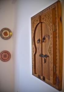 a wooden cabinet with a door on a wall at Darna Hostel in Tetouan