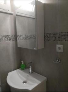 ein Bad mit einem Waschbecken und einem Spiegel in der Unterkunft Nikos house studios in Ofrynio