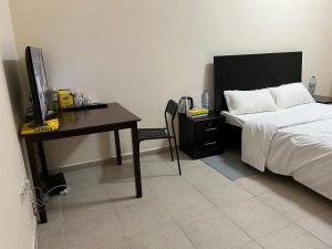 Master room attached bathroom في دبي: غرفة نوم مع سرير ومكتب مع جهاز كمبيوتر