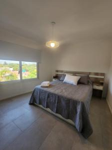 1 dormitorio con cama grande y ventana grande en Departamento Ribera en Ramallo