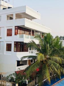 un edificio blanco con una palmera delante en Little Elephant Beach Resort, en Kovalam