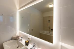 een witte badkamer met een wastafel en een spiegel bij Golf und Schnee in Zell am See