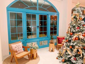 a christmas tree in a room with a blue door at Little Greece in Nanwan