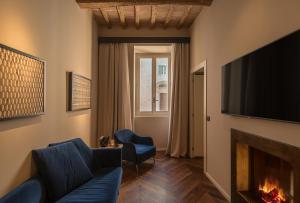 a living room with a fireplace and a tv at Times Suites & Bar in Perugia