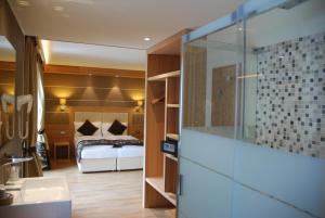 a bathroom with a bed and a sink in a room at Hotel Bondi in Livigno