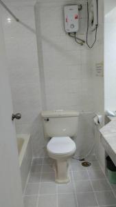 ein weißes Bad mit einem WC und einer Dusche in der Unterkunft Asia Inn Bangkok 2022 in Bangkok