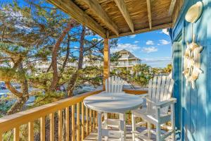 d'une table et de deux chaises sur un balcon avec vue sur l'océan. dans l'établissement Ocean Isle Retreat, à Ocean Isle Beach