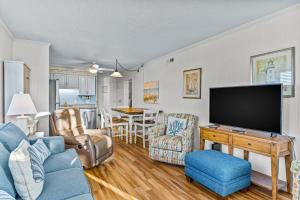 un salon avec un canapé bleu et une télévision dans l'établissement Ocean Isle Retreat, à Ocean Isle Beach