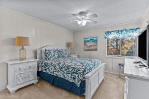 - une chambre avec un lit et un ventilateur de plafond dans l'établissement Ocean Isle Retreat, à Ocean Isle Beach
