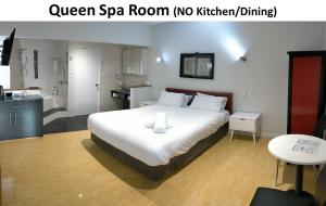 a bedroom with a large white bed and a bathroom at Dunsborough Apartments & Suites in Dunsborough